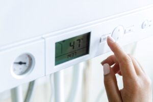 Someone adjusting the temperature on a modern boiler.